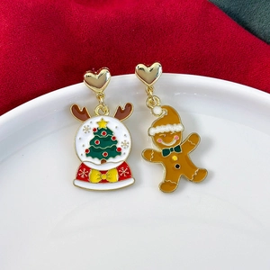 Detail of asymmetric Christmas tree snow globe and gingerbread man festive earrings