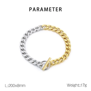 Detail of silver and gold toned stainless steel Figaro chain with OT clasp closure