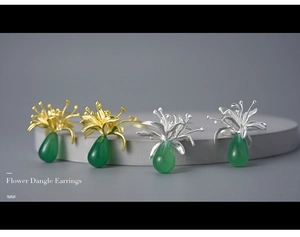 Detail of flower dangle earrings with green chalcedony drops in gold and silver finishes