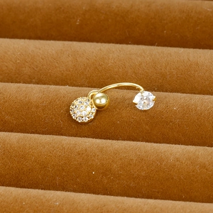 Macro shot of gold-plated curved barbell piercing with clear zircon flower pendants
