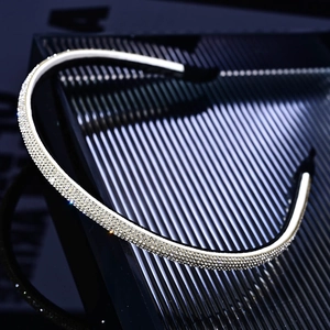 Detailed macro view of sparkling silver rhinestones on a slim black headband for women