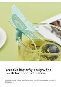 Detailed view of a mint green butterfly tea strainer clipped on a glass cup rim