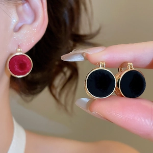 Detailed view of vintage gold-rimmed earrings with velvet flocking and pearl texture