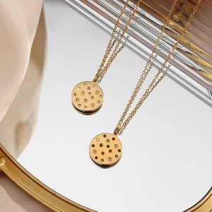 Macro detail of gold circle pendants with clear and colorful zircons on a tray