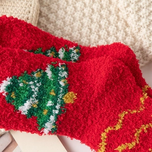 Gros plan détaillé de chaussettes de Noël rouges pelucheuses avec motif sapin doux
