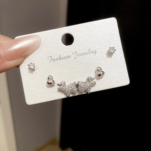 Détails d'ensemble de boucles d'oreilles en argent avec motifs gourde et chiot
