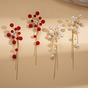 Elegant gold drop earrings with zircon, pearls and long tassels on beige background