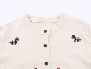Detail view of beige knit cardigan with brown buttons and pony embroidery motifs