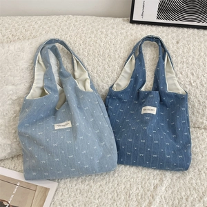 Vue détaillée de sacs cabas en denim bleu clair et foncé avec motifs nœuds et cœurs