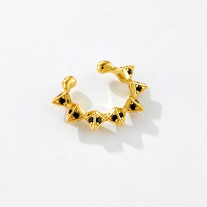 Detail of gold geometric ear cuff featuring black triangular stones on white background