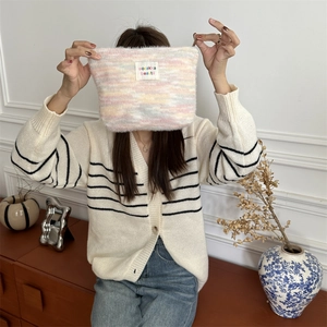 Detail of plush rainbow makeup bag with suzakka beauté label and zipper closure