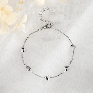 Elegant S925 silver heart bracelet with lobster clasp on white silk background