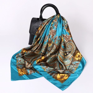 Detailed paisley print silk scarf draped over a black crocodile pattern handbag