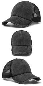 Detail van een gewassen zwarte vintage baseballcap met ademend mesh en distressed rand