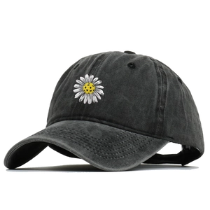 Close-up of intricate daisy flower embroidery on vintage washed cotton baseball cap