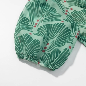 Detail of elastic cuffs and green floral print fabric on backless slim maxi dress