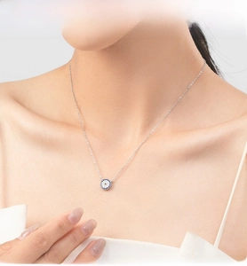 Close-up of S925 sterling silver necklace with sparkling blue evil eye pendant on a model