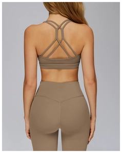 Detail of cross-strap back design on tan sports bra and high-waist yoga leggings