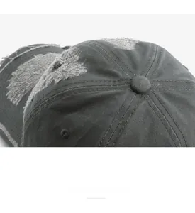 Detail of distressed dark grey baseball cap with vintage frayed edges and clean stitching
