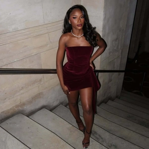 Elegant burgundy velvet off-shoulder mini dress detail on model with streamer accents