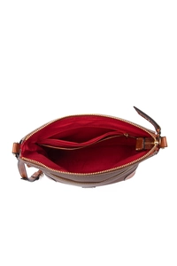 Detail view of the deep brown pebbled leather crossbody bag with vibrant red interior lining