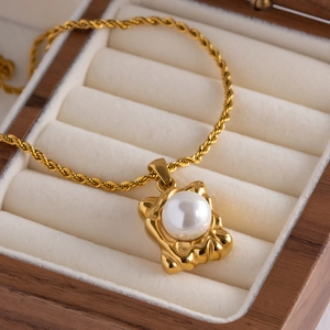 Detailansicht der goldenen Kordelkette mit quadratischem Anhänger und glänzender Perle