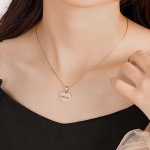 Macro view of rose gold heart pendant necklace with ÉUNICA engraving and tiny crystal diamond