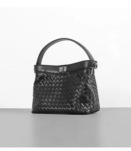 Close-up of black woven handbag with classic silver twist lock and luxury leather texture