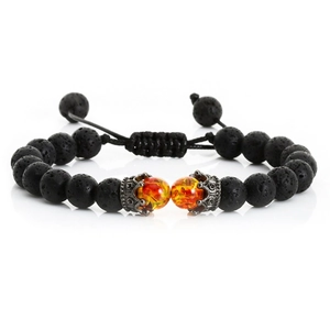 Close-up of lava stone beads with crown charm and adjustable woven string on bracelet