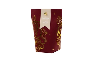 Close-up of gold foil floral pattern on burgundy gift box with Thank You tag