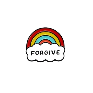 Detail of a rainbow enamel pin with white clouds and black Forgive lettering