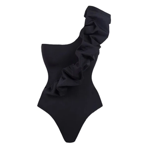 Detail of elegant black one-shoulder swimsuit with large 3D ruffle trim and textured fabric