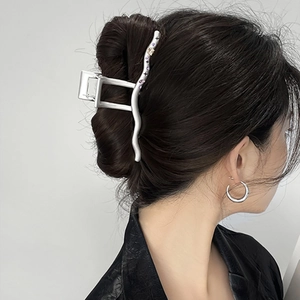 Detailed side view of y2k silver metal hair claw with purple crystals on wavy design