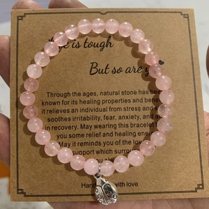 Pink stone bead bracelet with a silver ladybug charm on an English message gift card