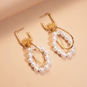 Golden drop earrings with white pearls and geometric metal rings in luxury style