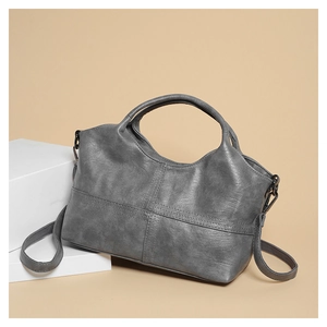 Detailed side view of soft grey faux leather tote bag with sturdy handles and shoulder strap