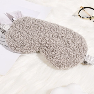 Gray teddy plush sleep eye mask with silk elastic strap on soft white background