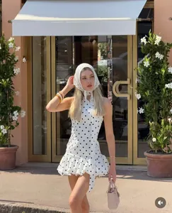 Détail de mini robe blanche à pois avec ourlet à volants et foulard en dentelle assorti