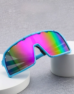 Close-up of rainbow mirrored cycling sunglasses with blue speckled frame on white pillars