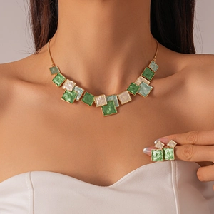 Detail view of geometric green and white enamel square necklace with gold-plated chain