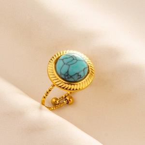 Detail shot of golden adjustable ring with a round turquoise stone and sunburst texture