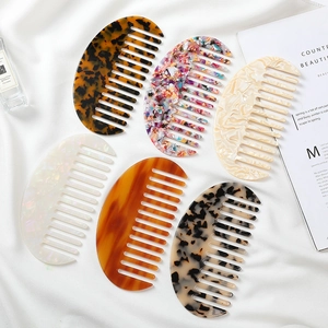 Flat lay of six diverse acetate wide-tooth hair combs in elegant marble and floral patterns