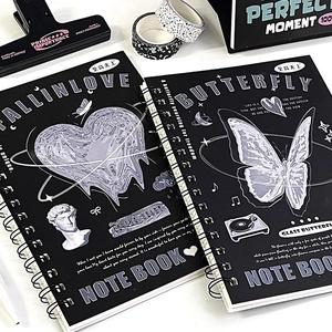 Detailed view of black spiral notebooks featuring liquid metal butterfly and heart graphics