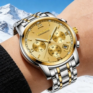 Detailed close-up of gold and silver men's watch with luminous dial and date display