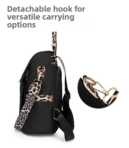 Detail of detachable golden hooks and leopard print strap on the black nylon backpack