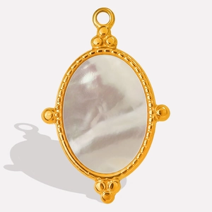 Macro shot of oval white mother of pearl pendant set in gold stainless steel frame