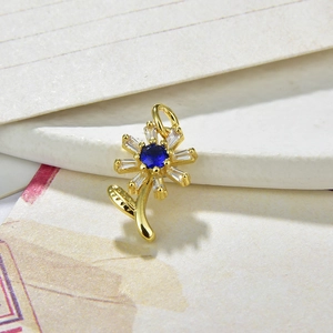 Golden sunflower necklace pendant featuring a blue center stone and white zircon petals