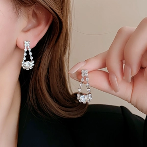 Close-up of elegant silver teardrop tassel earrings with sparkling crystals on a model