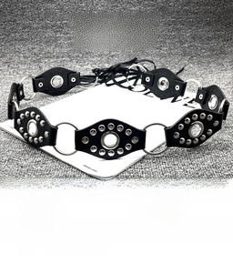 Detail showing Y2K punk belt with silver metal rings, rivets and leather oval patches