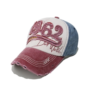 Detail of vintage 1962 embroidery and distressed patchwork cotton on the baseball cap